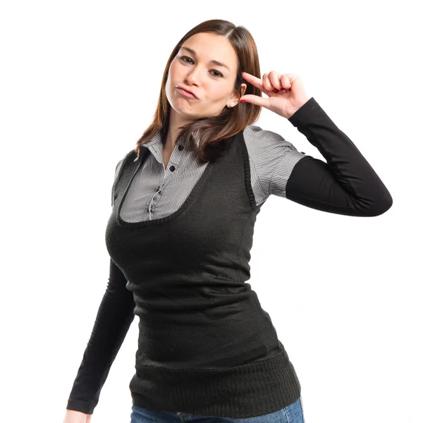 Young girl doing a tiny sign over white background — Stock Photo, Image