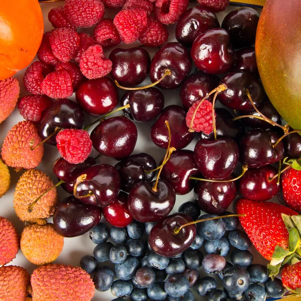 Flera färgglada frukter över vit bakgrund — Stockfoto
