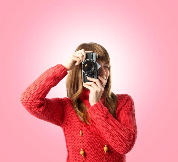 Menina tirando uma foto sobre fundo rosa — Fotografia de Stock