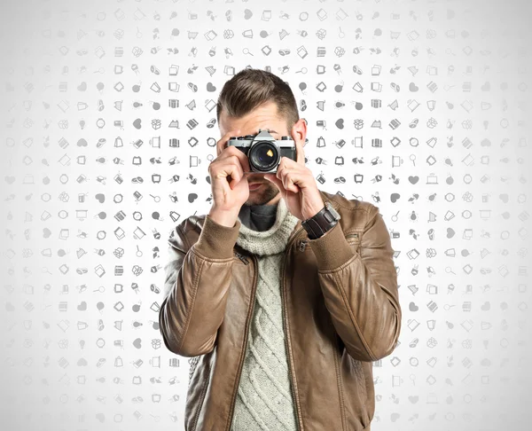 Man photographing somebody over icons background — Stock Photo, Image