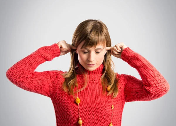 Jovem mulher bonita cobrindo seus ouvidos sobre fundo cinza — Fotografia de Stock