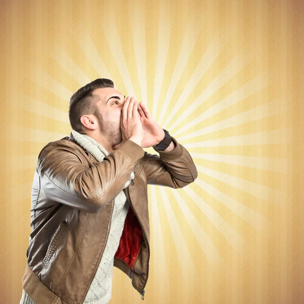 Young man screaming over textured yellow background — Stock Photo, Image