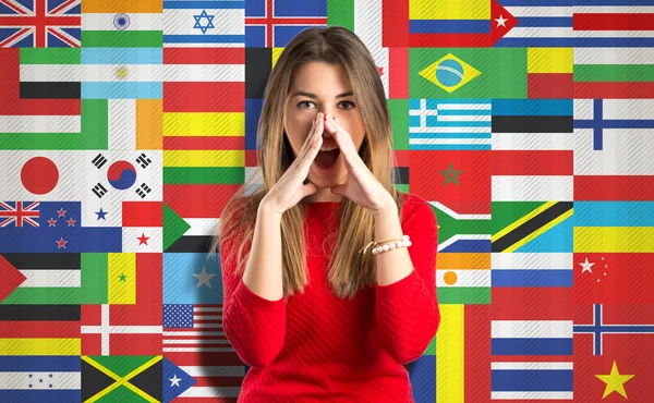Young girl shouting over flags background — Stock Photo, Image