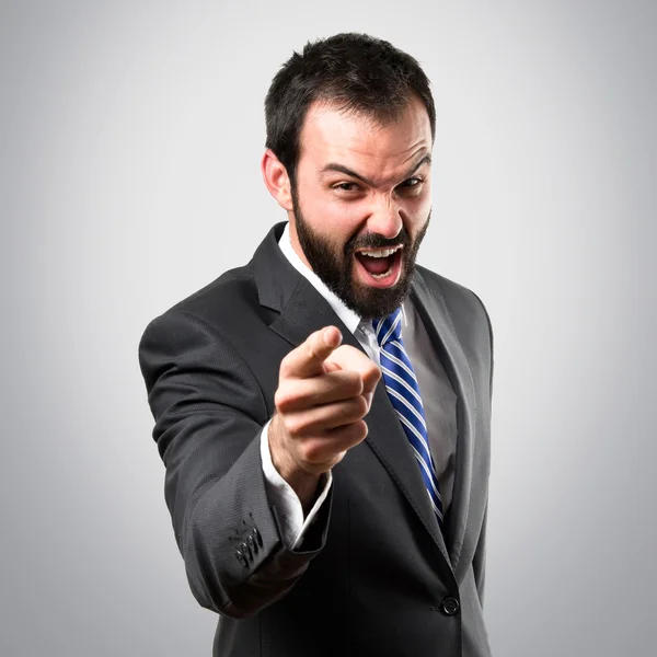 Young businessman screaming over grey background — Stock Photo, Image