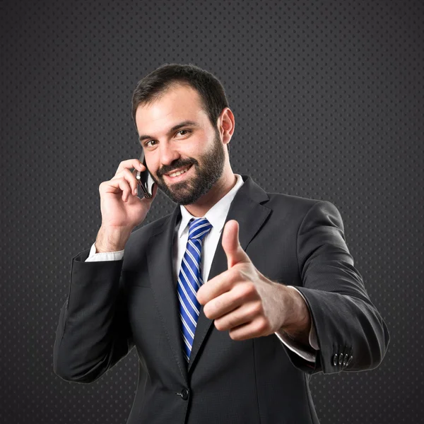 Młodzi biznesmeni mówić do mobilnych na czarnym tle. — Zdjęcie stockowe