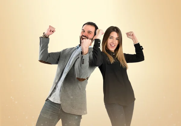 Pareja ganadora sobre fondo ocre — Foto de Stock