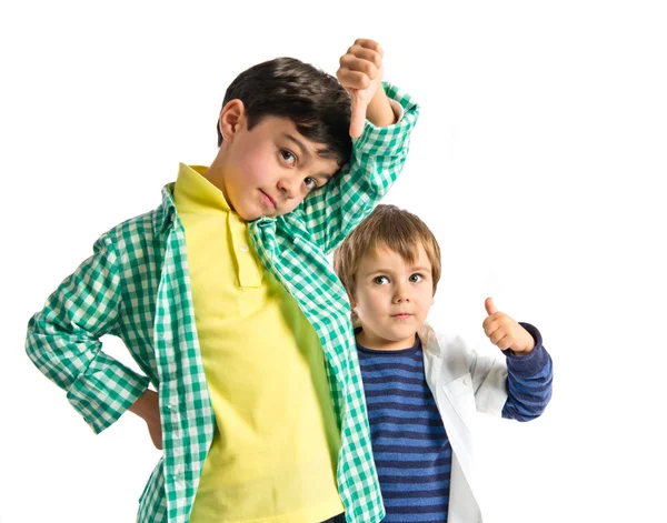 Niños haciendo buena y mala señal sobre fondo blanco —  Fotos de Stock