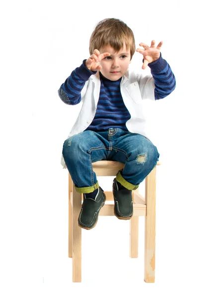 Enfant jouant sur chaise en bois sur fond blanc — Photo