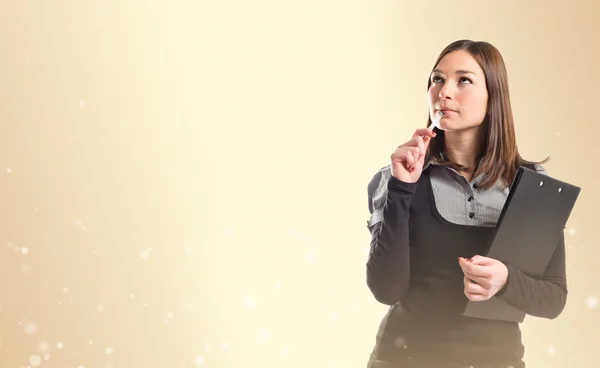 Young student thinking over ocher background — Stock Photo, Image