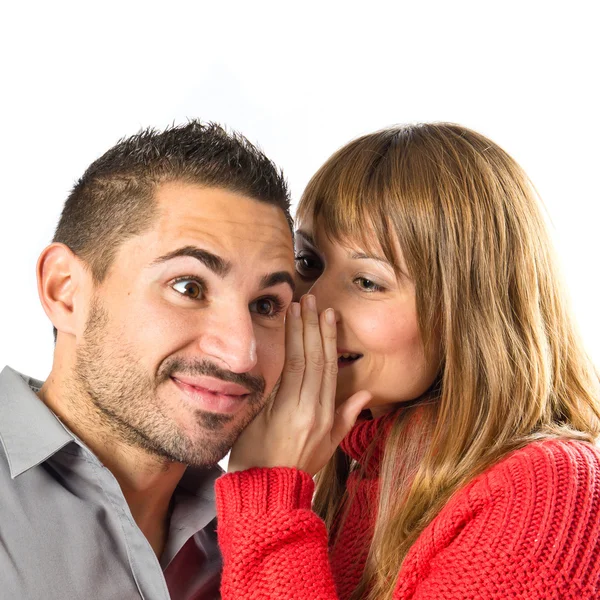 Young girl whispering to her boyfriend over white background — Stock Photo, Image