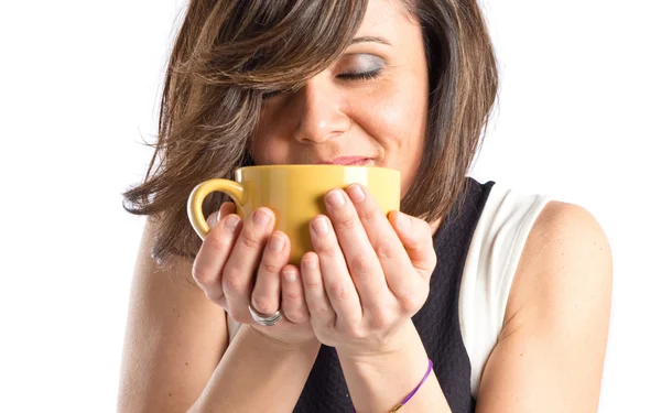 Menina bonita cheirando uma xícara de café sobre fundo branco — Fotografia de Stock