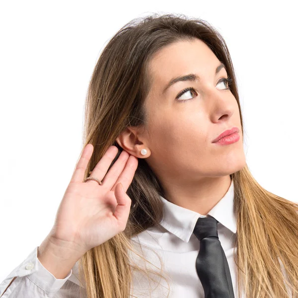 Joven empresaria escuchando sobre fondo blanco aislado —  Fotos de Stock