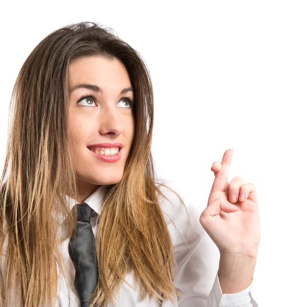Pretty businesswoman with her fingers crossing over white background — Stock Photo, Image