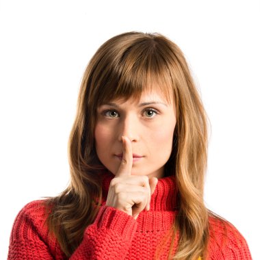 Genç kız izole edilmiş beyaz arka planda sessizlik jesti yapıyor. 