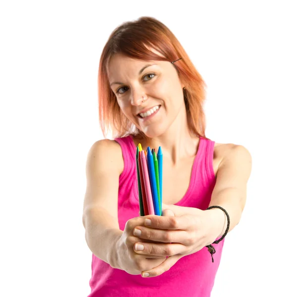 Joven pelirroja sosteniendo crayones sobre fondo blanco —  Fotos de Stock