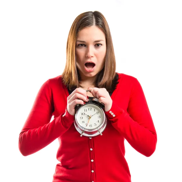 Surpreendida jovem segurando um relógio antigo sobre fundo branco — Fotografia de Stock