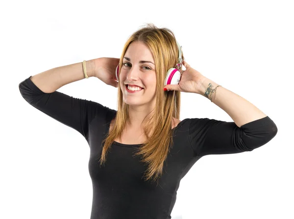 Joven chica rubia escuchando música sobre fondo blanco —  Fotos de Stock