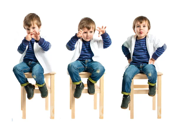 Enfant jouant sur chaise en bois sur fond blanc — Photo