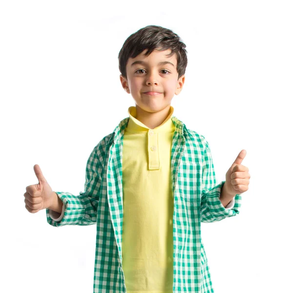 Boy making a OK sign on wooden chair over white background — Stock Photo, Image