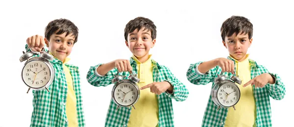 Boy holding an antique clock over white background — Stock Photo, Image