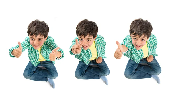 Roztomilé dítě dělat gesto vítězství nad bílým pozadím — Stock fotografie