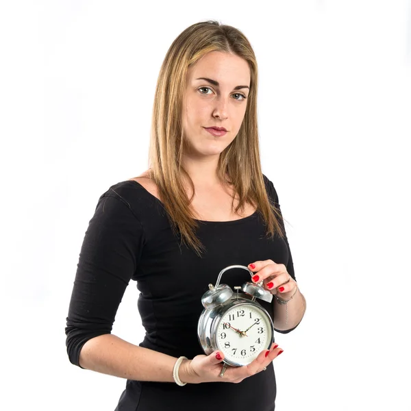 Chica joven sosteniendo un reloj antiguo sobre fondo blanco Imágenes de stock libres de derechos