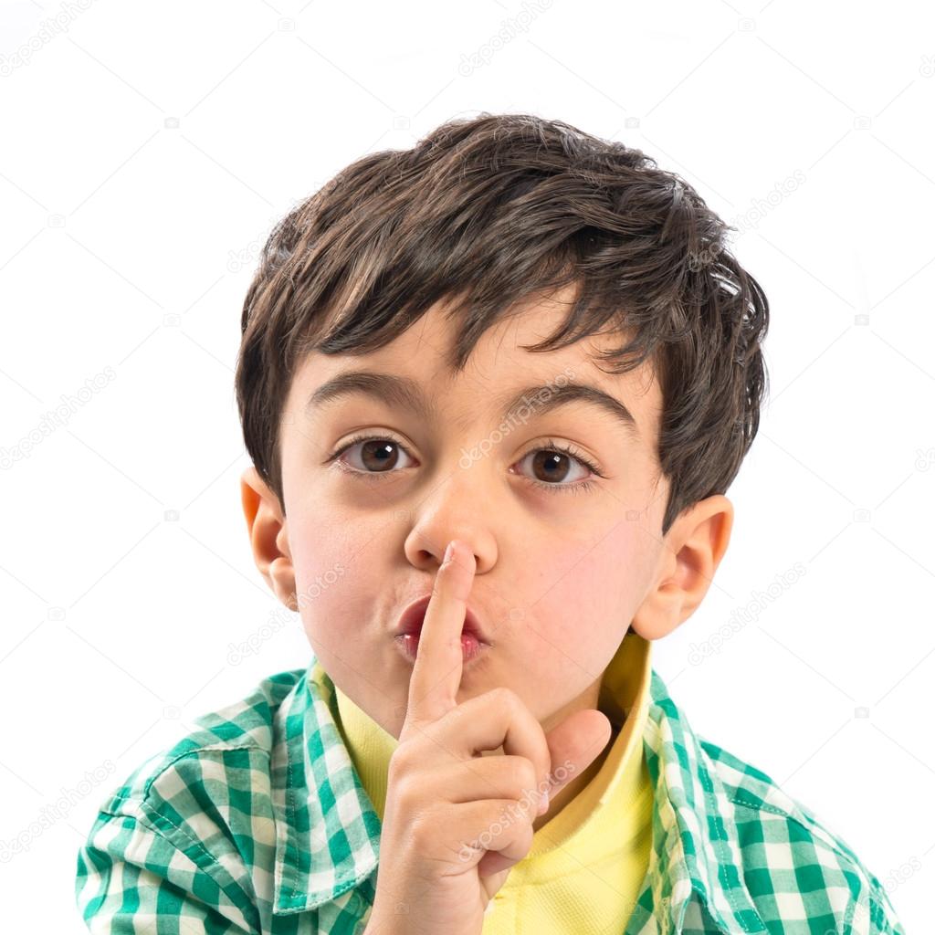 Kid doing silence gesture over white background 