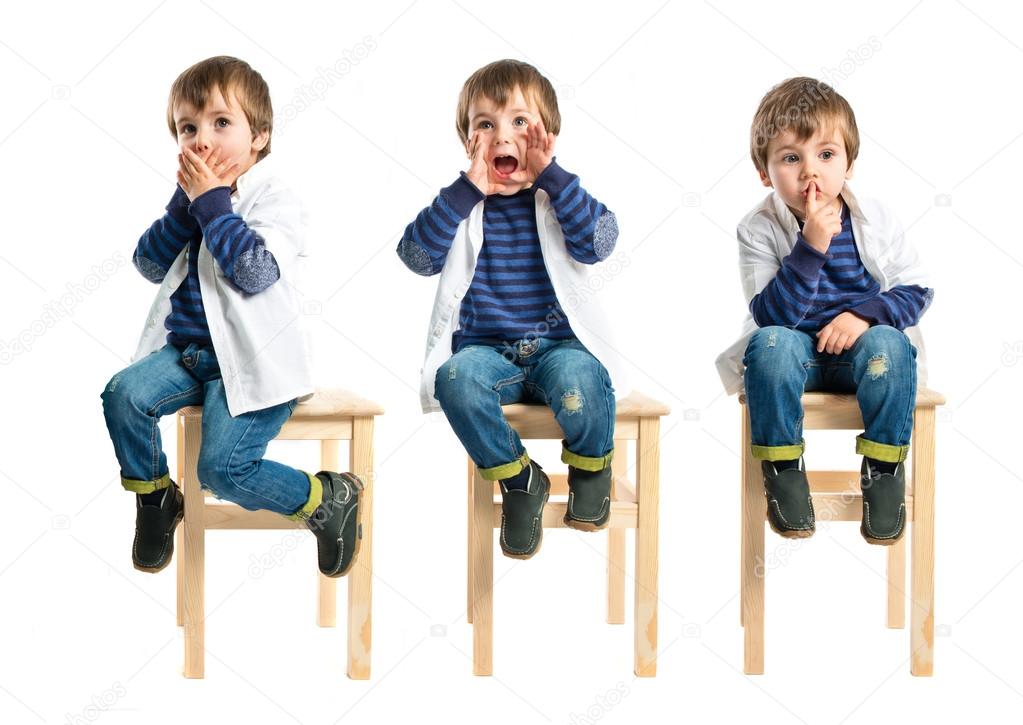Kid shouting and doing silence gesture over white background Stock