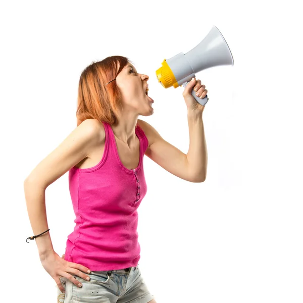 Рыжая девушка кричит с мегафоном на белом фоне — стоковое фото