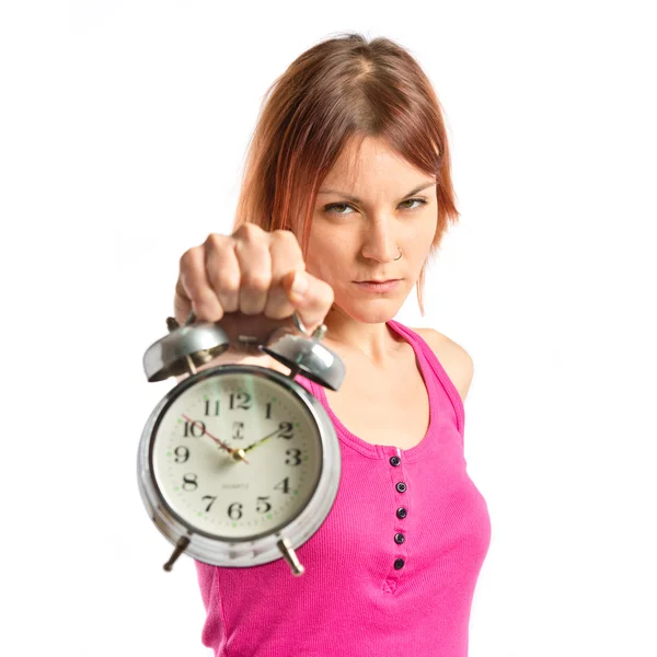 Sérieux rousse fille tenant une horloge sur fond blanc Images De Stock Libres De Droits