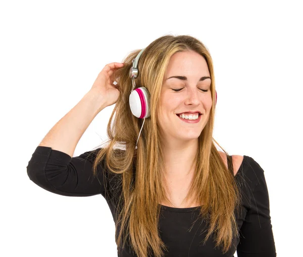 Young blonde girl listening music over white background — Stock Photo, Image
