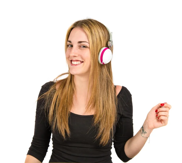 Young blonde girl listening music over white background — Stock Photo, Image