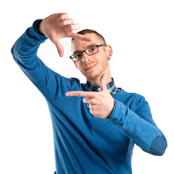 Young man doing a frame sign over white background — Stock Photo, Image