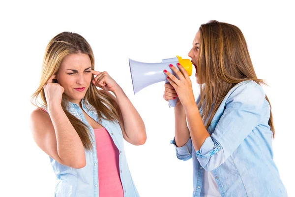 Girl shoutimg with a megaphone at her friend — Stock Photo, Image