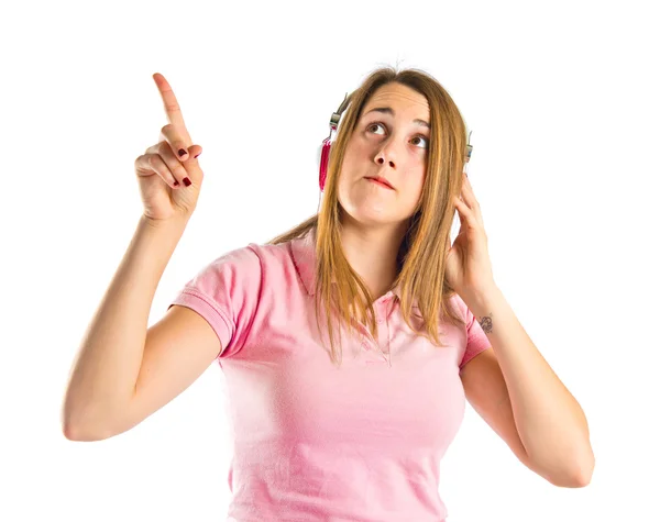 Jovem menina loira ouvindo música sobre fundo branco — Fotografia de Stock