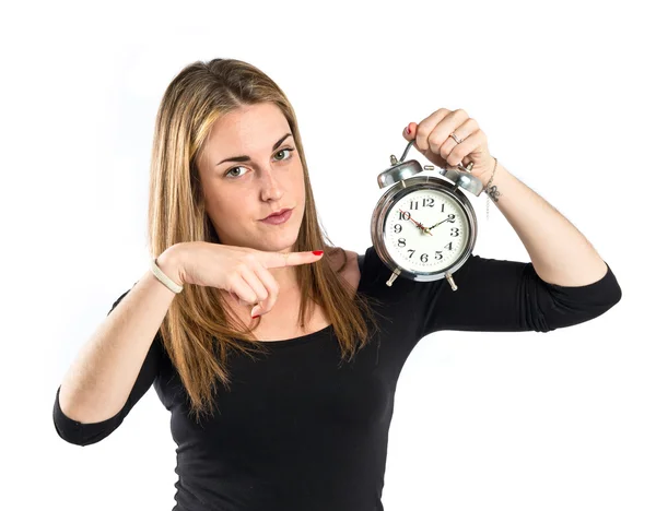 Feliz chica rubia sosteniendo un reloj sobre fondo blanco Imagen de stock