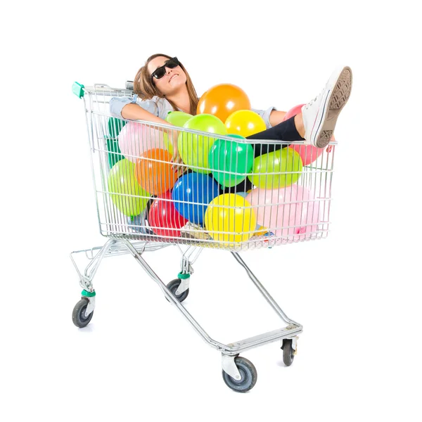 Dziewczyna z wielu balonów wewnątrz supermarketu koszyk na białym tle — Zdjęcie stockowe