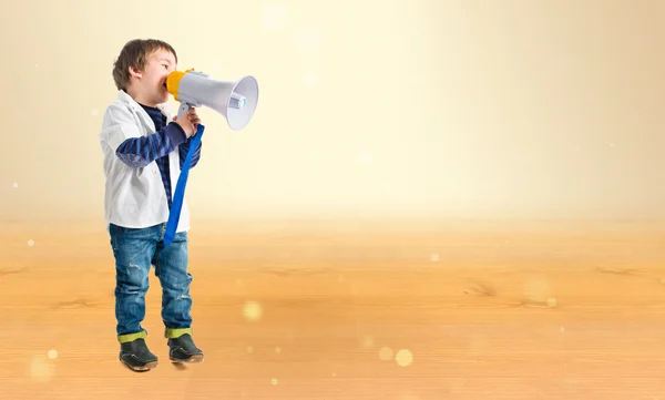Jongen schreeuwen door megafoon over oker achtergrond — Stockfoto