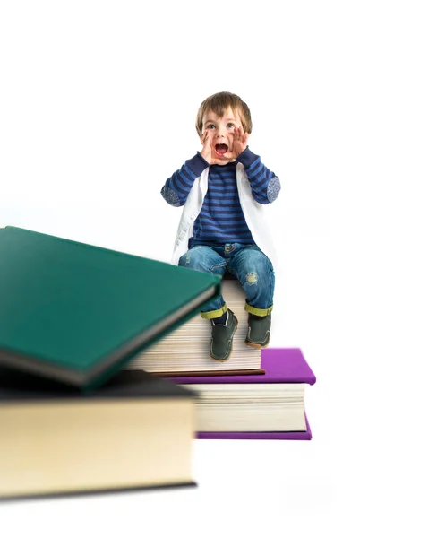 Kind schreit auf Büchern vor weißem Hintergrund — Stockfoto