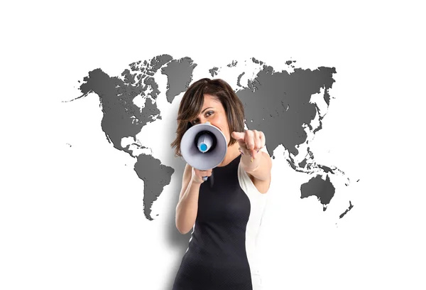 Pretty girl shouting with a megaphone over map background — Stock Photo, Image