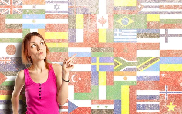 Young girl thinking over flags background — Stock Photo, Image