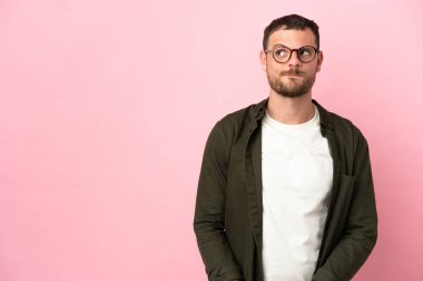 Genç Brezilyalı bir adam pembe arka planda izole edilmiş.