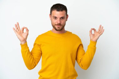Zen pozisyonunda beyaz arka planda izole edilmiş genç Brezilyalı adam.