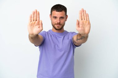 Beyaz arka planda izole edilmiş genç Brezilyalı adam dur hareketi yapıyor ve hayal kırıklığına uğruyor.