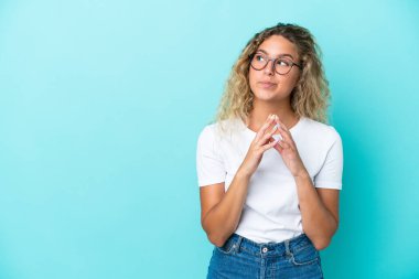 Mavi arka plandaki kıvırcık saçlı kız bir şeyler planlıyor.