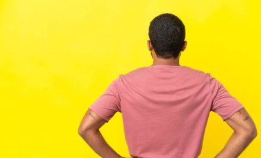 Arka planda sarı arka planda izole genç latin adam