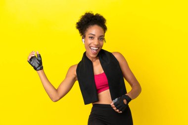 Genç Afrikalı sporcu kadın sarı arka planda izole edilmiş gitar hareketi yapıyor.