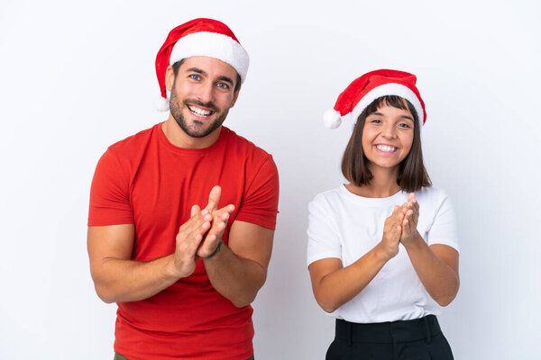 Young couple with christmas hat isolated on white background applauding after presentation in a conference