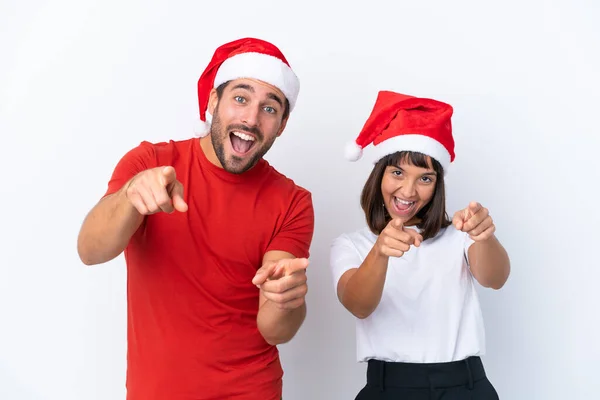 Junges Paar Mit Weihnachtsmütze Auf Weißem Hintergrund Zeigt Lächelnd Mit — Stockfoto