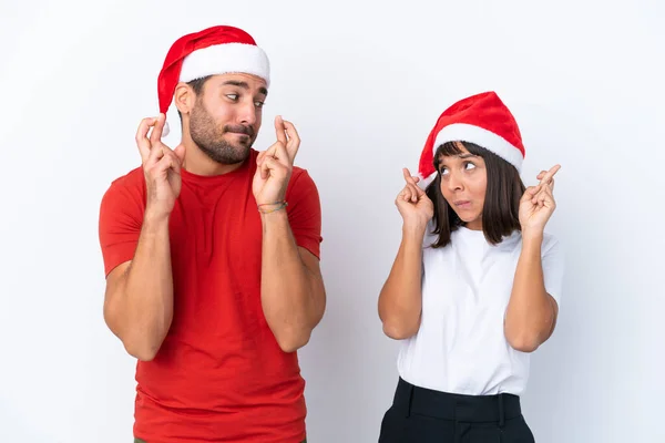 Young Couple Christmas Hat Isolated White Background Fingers Crossing Wishing — Stock Photo, Image